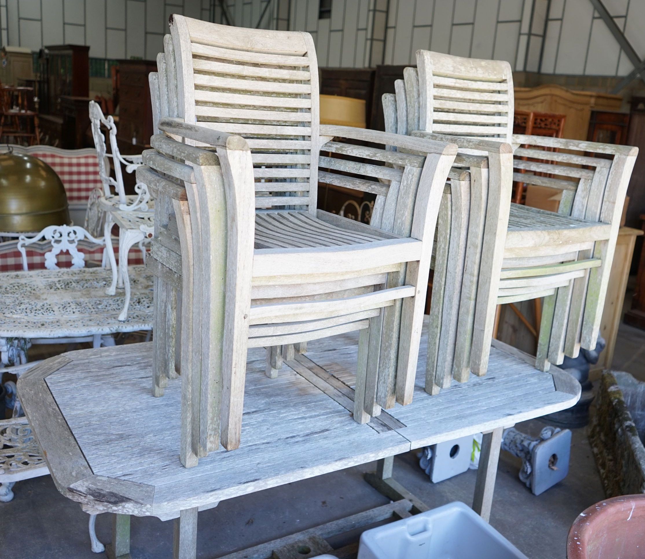 A rectangular weathered teak extending garden table, 250cm extended, width 100cm, height 74cm together with eight matching elbow chairs